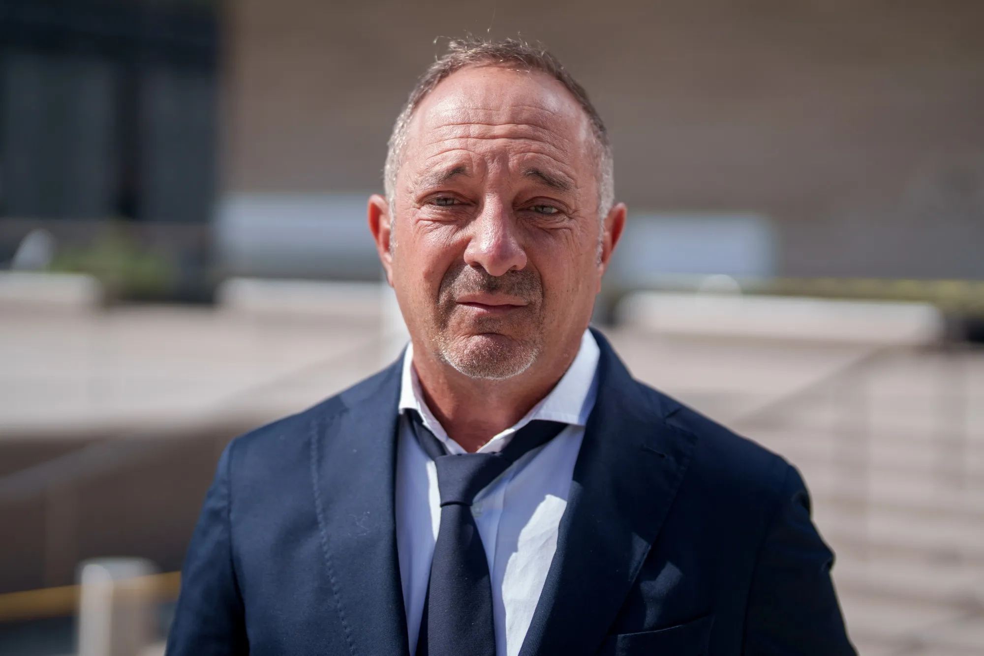 Andrew Left, founder of Citron Research, standing outside a courthouse in a dark suit.