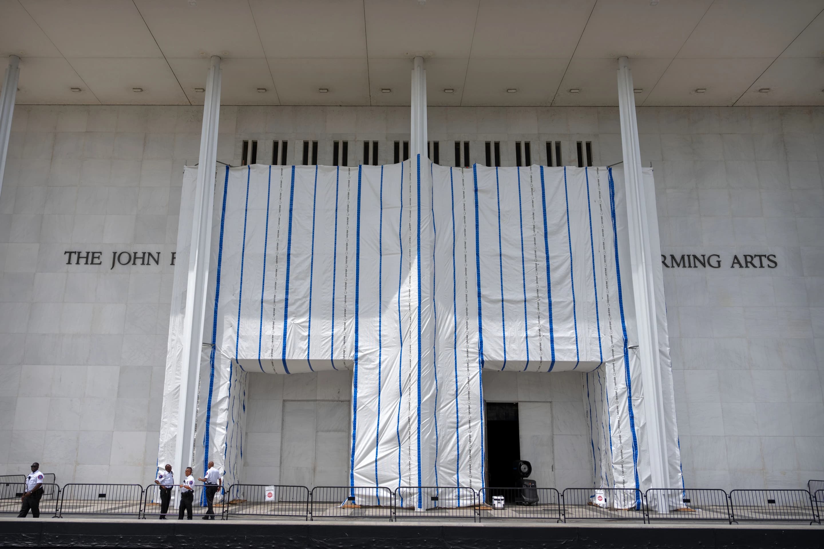 The John F. Kennedy Center for the Performing Arts with its facade wrapped in construction tarps during renovation work.