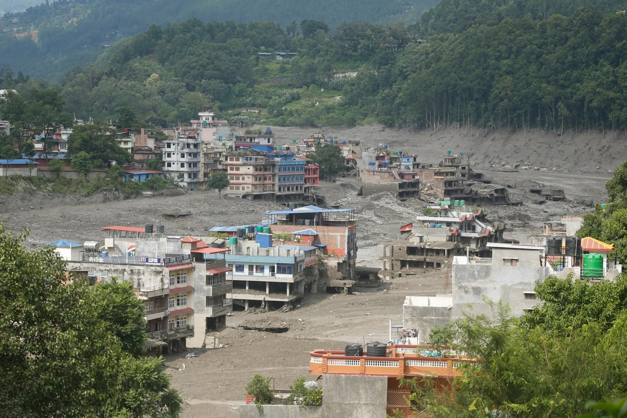 Buildings along the Trishuli River in Nepal buried in mud and debris after flash flooding.