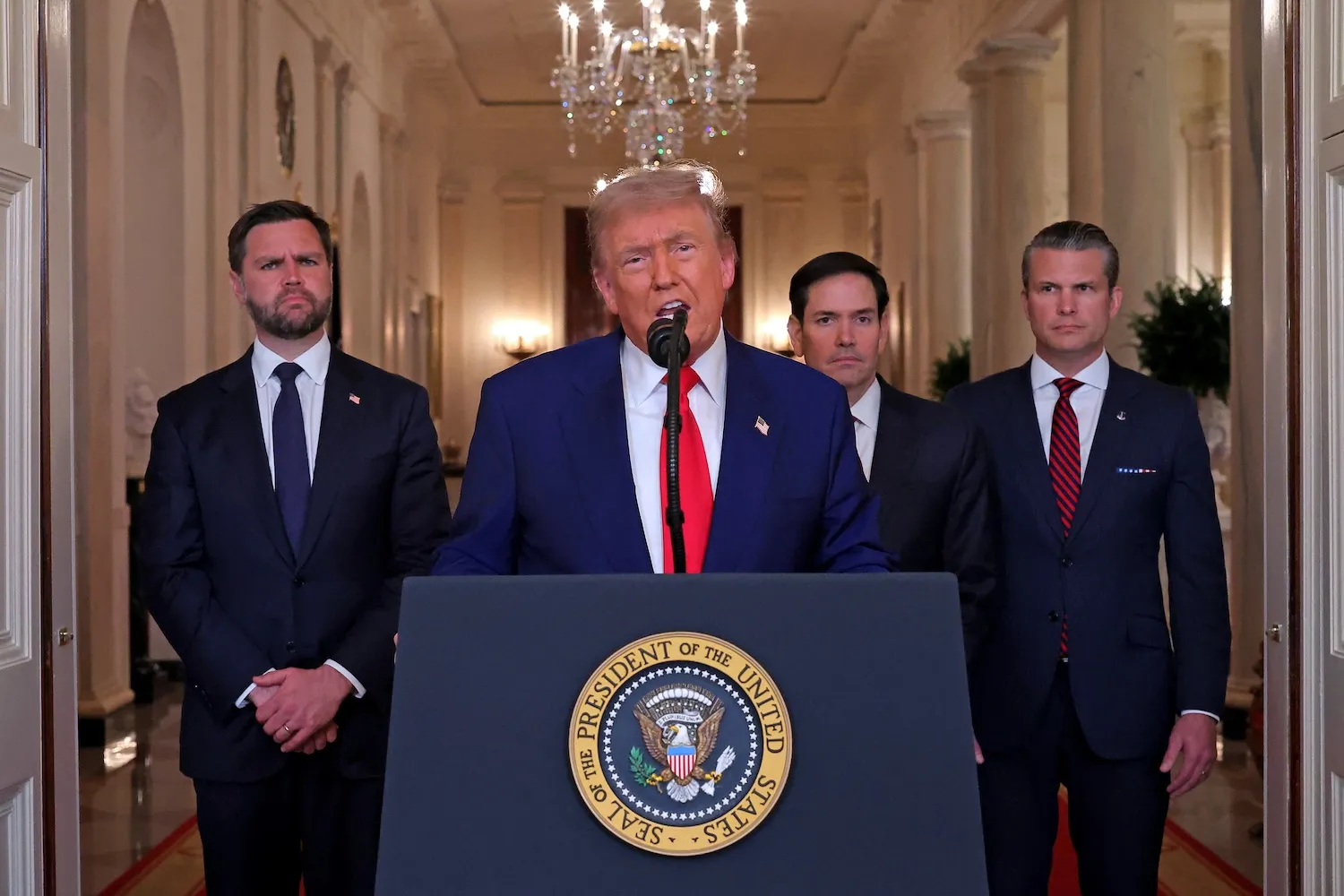 President Trump speaks at a White House lectern flanked by Vice President Vance and administration officials.