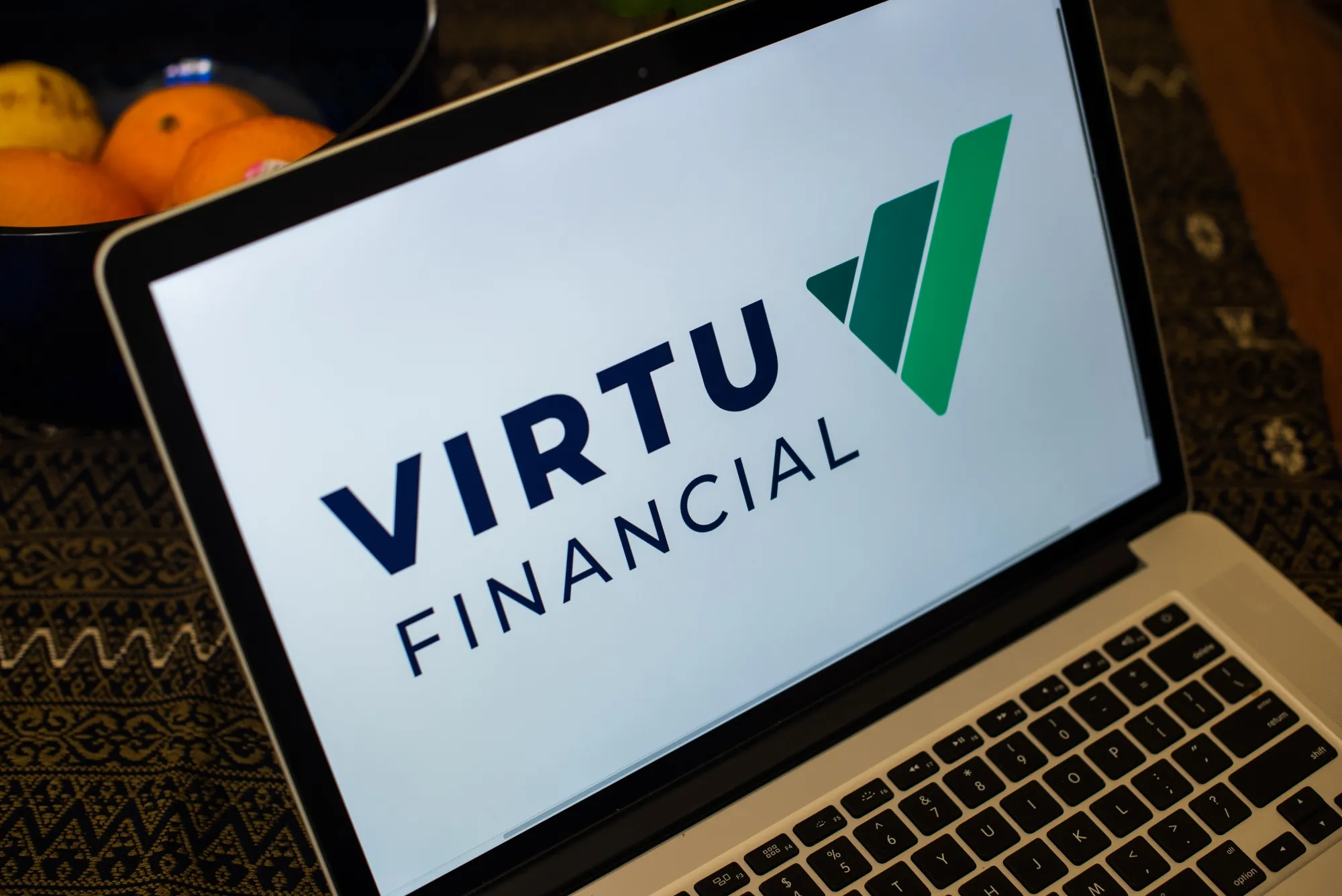 A laptop screen displaying the Virtu Financial logo.
