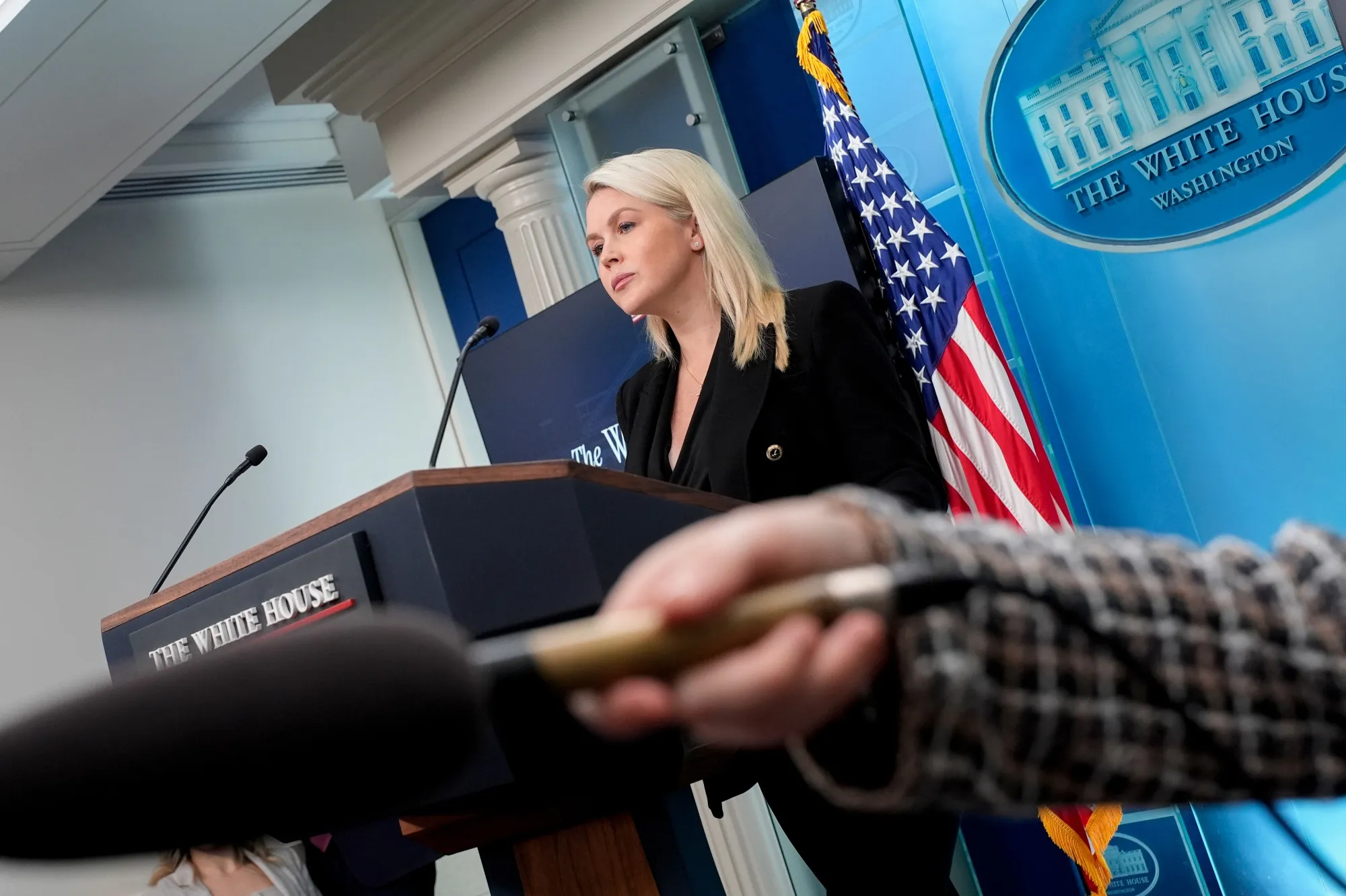 A White House official speaks at the press briefing room podium.