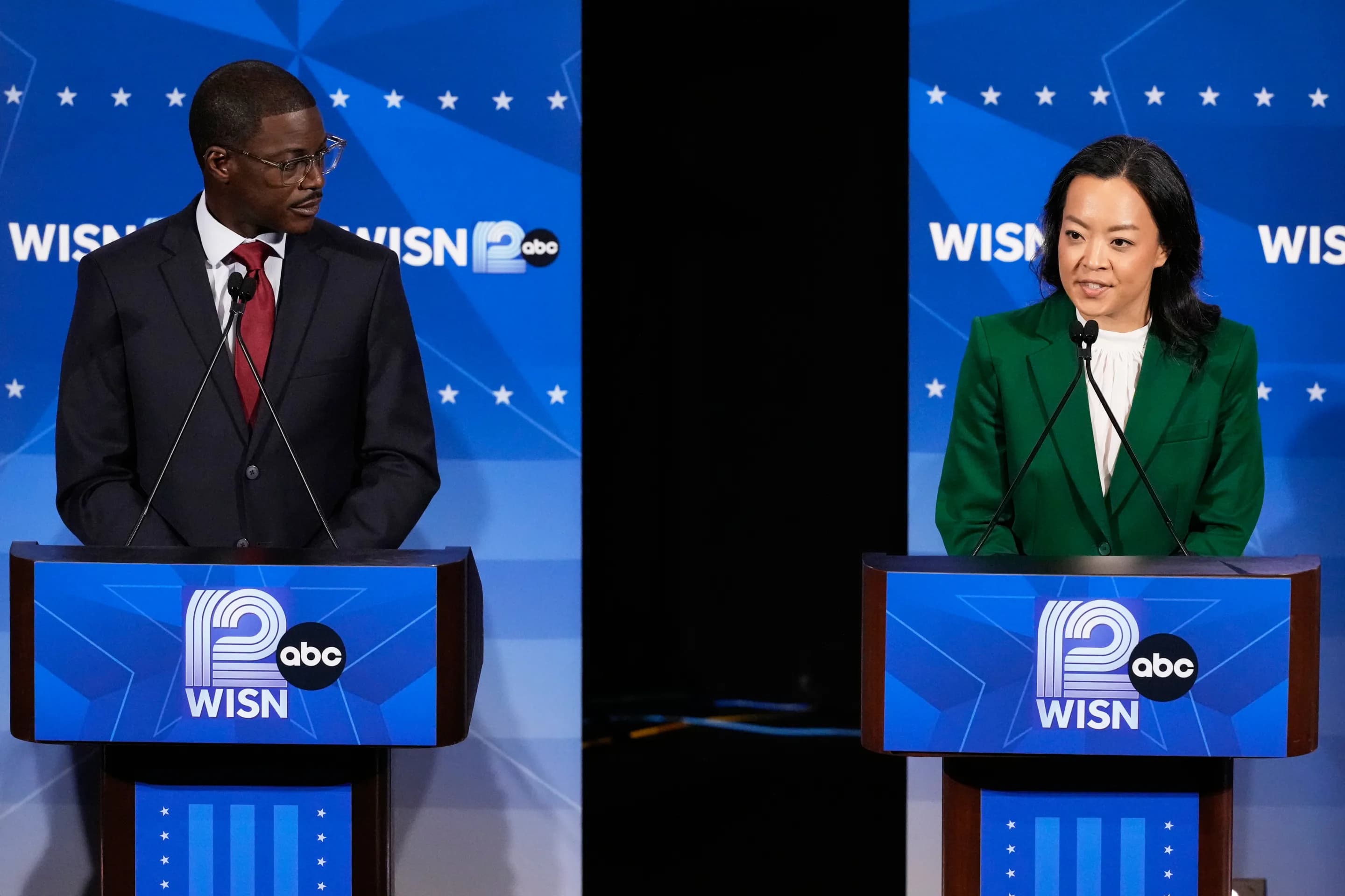 Two Democratic primary candidates standing at podiums during a televised debate hosted by a Wisconsin ABC affiliate.