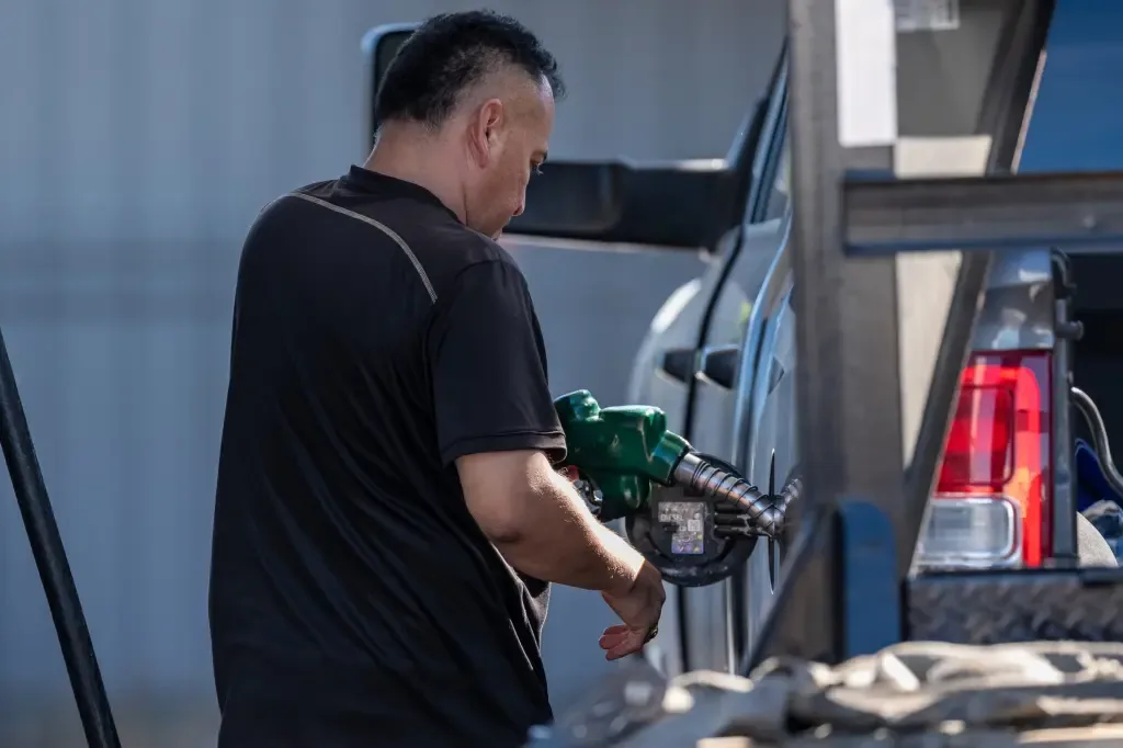 A man fills up his truck with gas at a filling station
