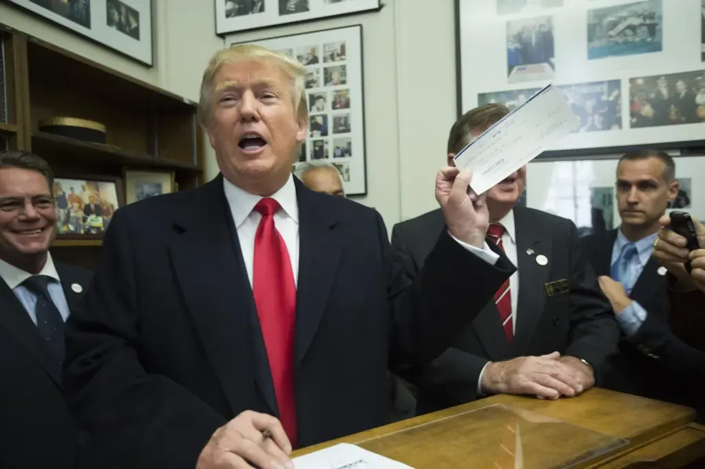 Donald Trump holding up a check while surrounded by supporters