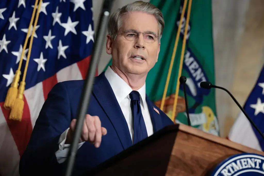 U.S. Treasury official speaking at a podium in front of American flags
