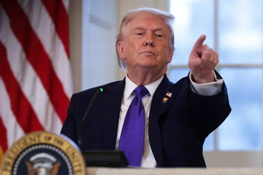 President Trump pointing while speaking at a podium in front of an American flag